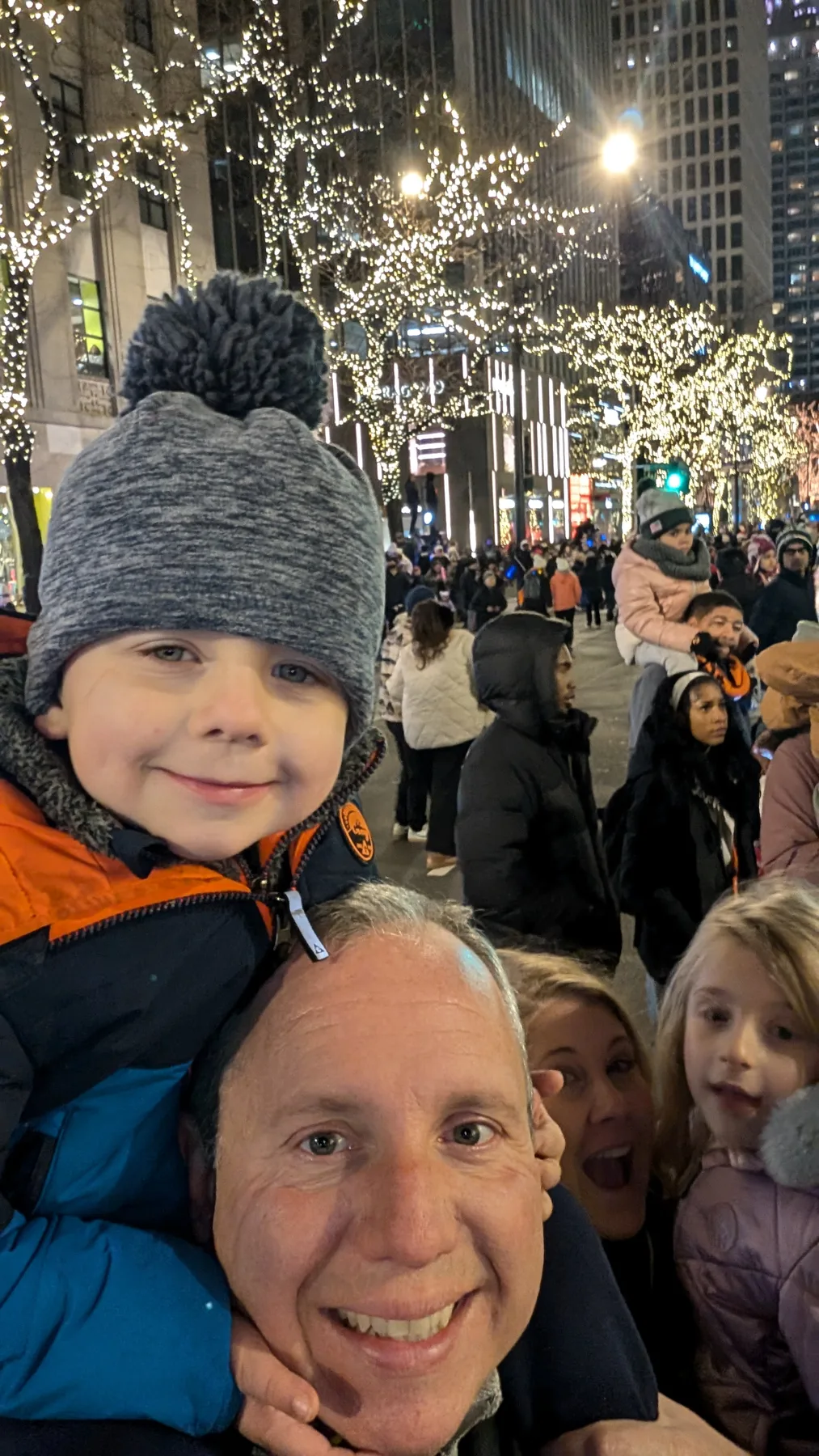 Caleb bundled up among holiday lights in the city with family