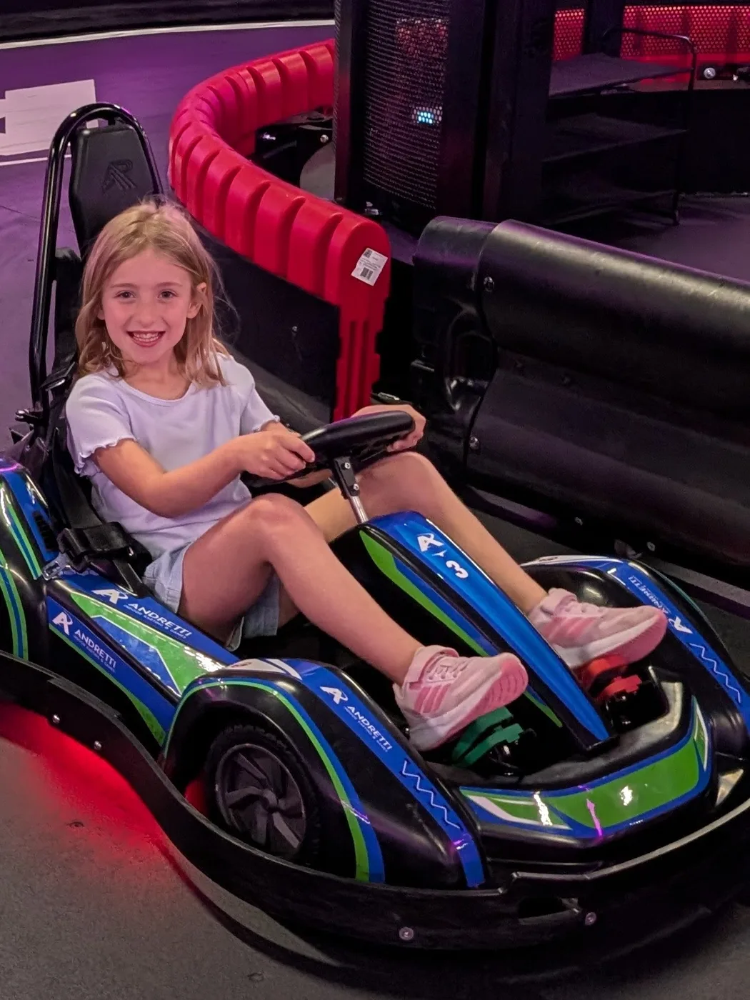 Abigail smiling behind the wheel of a go-kart