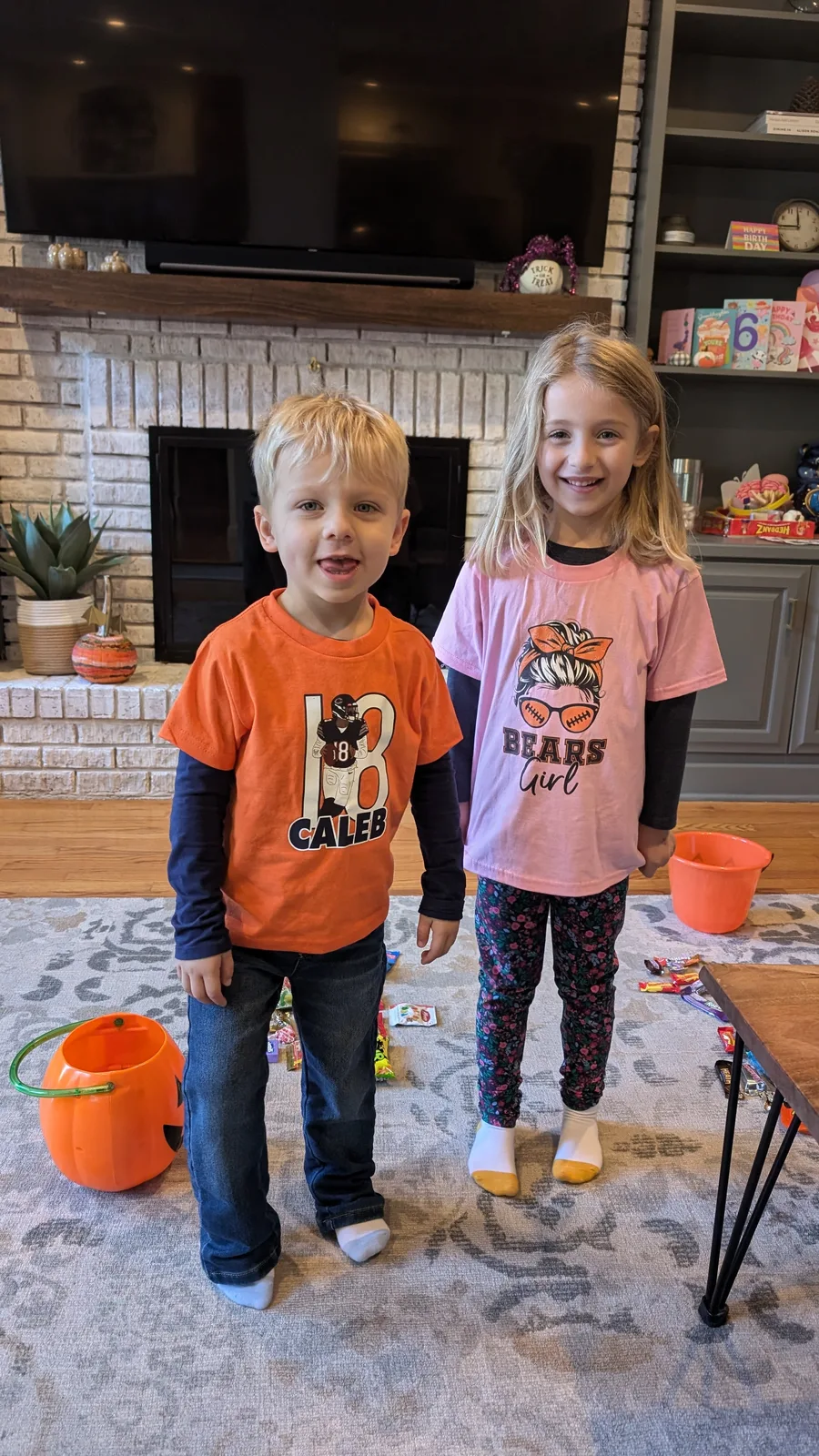 Abigail and Caleb in costume with trick-or-treat buckets at home